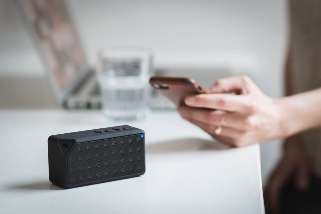 Portable wireless Bluetooth speaker connected to smartphone indoors