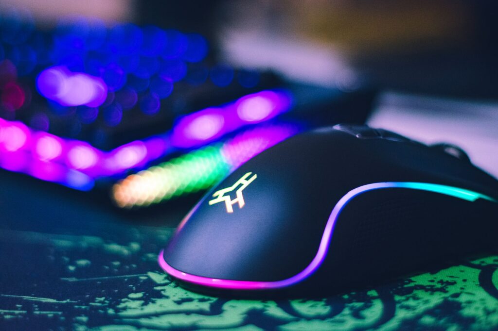Colorful RGB gaming mouse and illuminated keyboard close up
