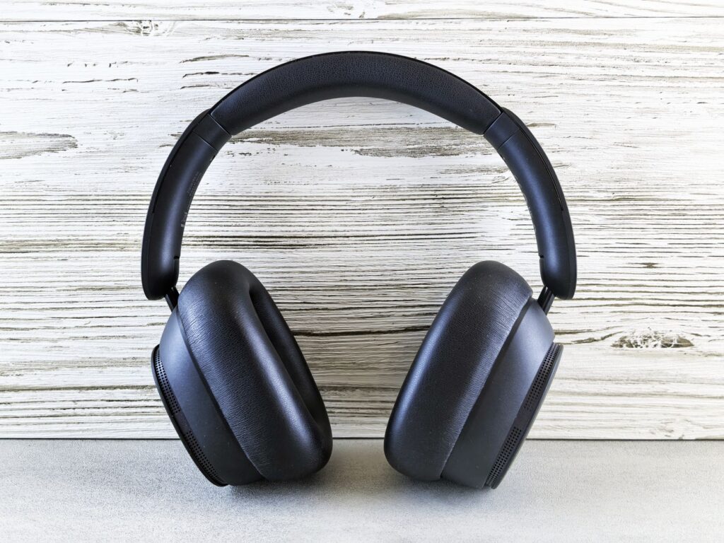 Stylish black over-ear noise cancelling headphones on wooden backdrop