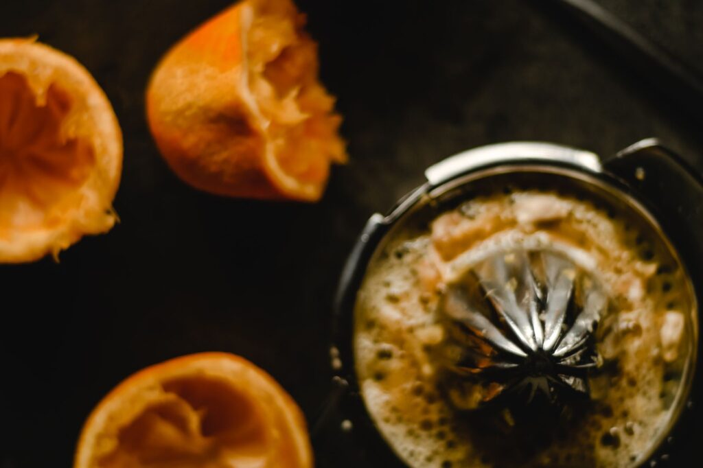 Juicer machine with fresh citrus fruits for juice extraction in kitchen