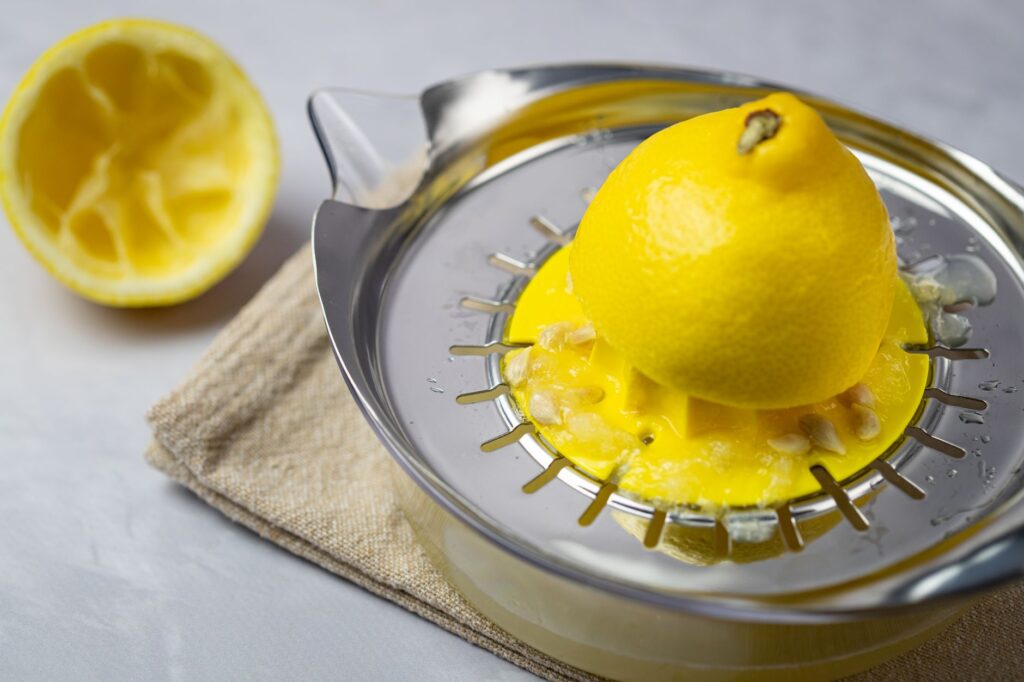 Lemon being juiced on metal citrus juicer - best juicers India 2026