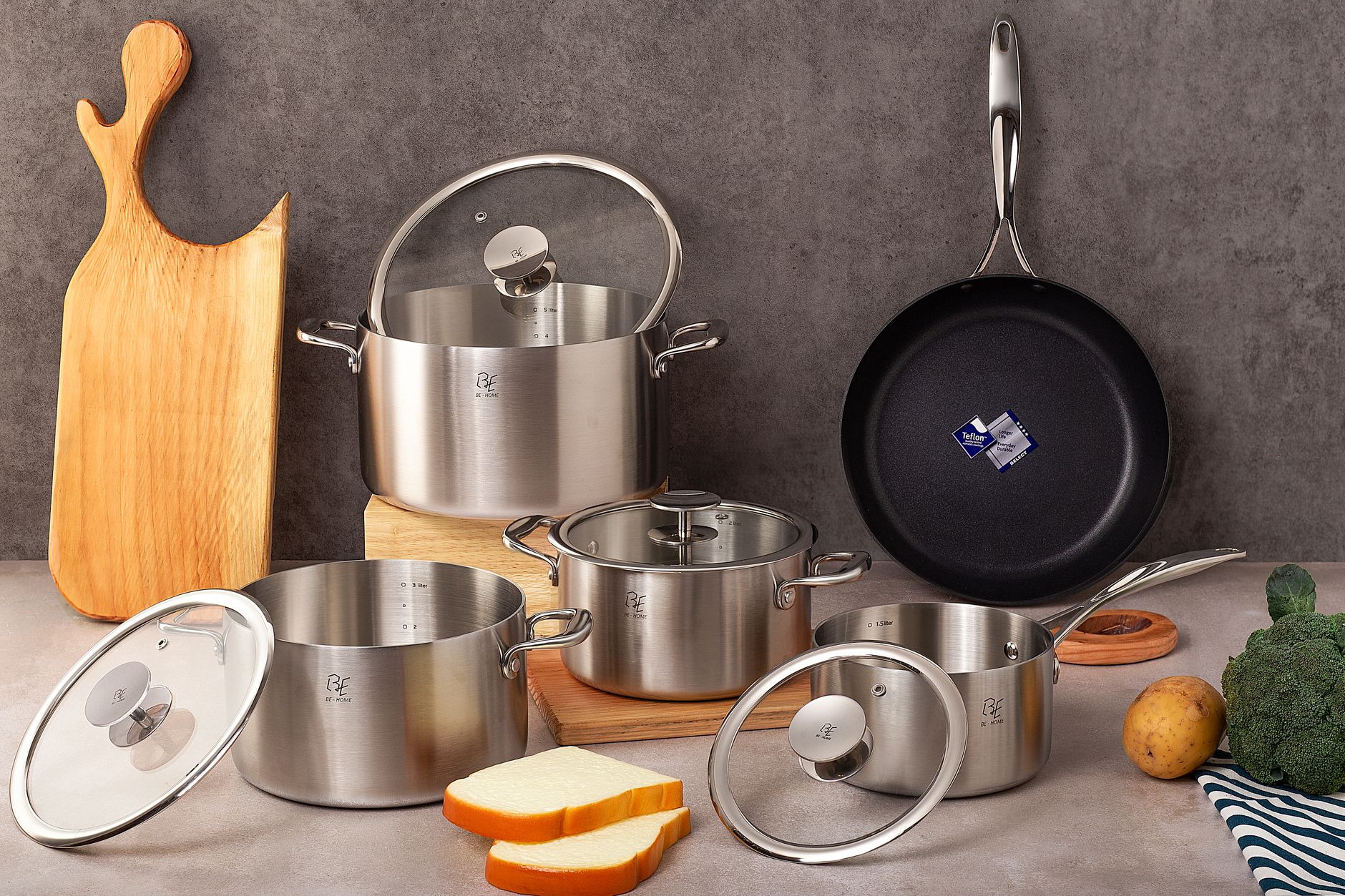 Best stainless steel cookware set India with vegetables and wooden cutting board