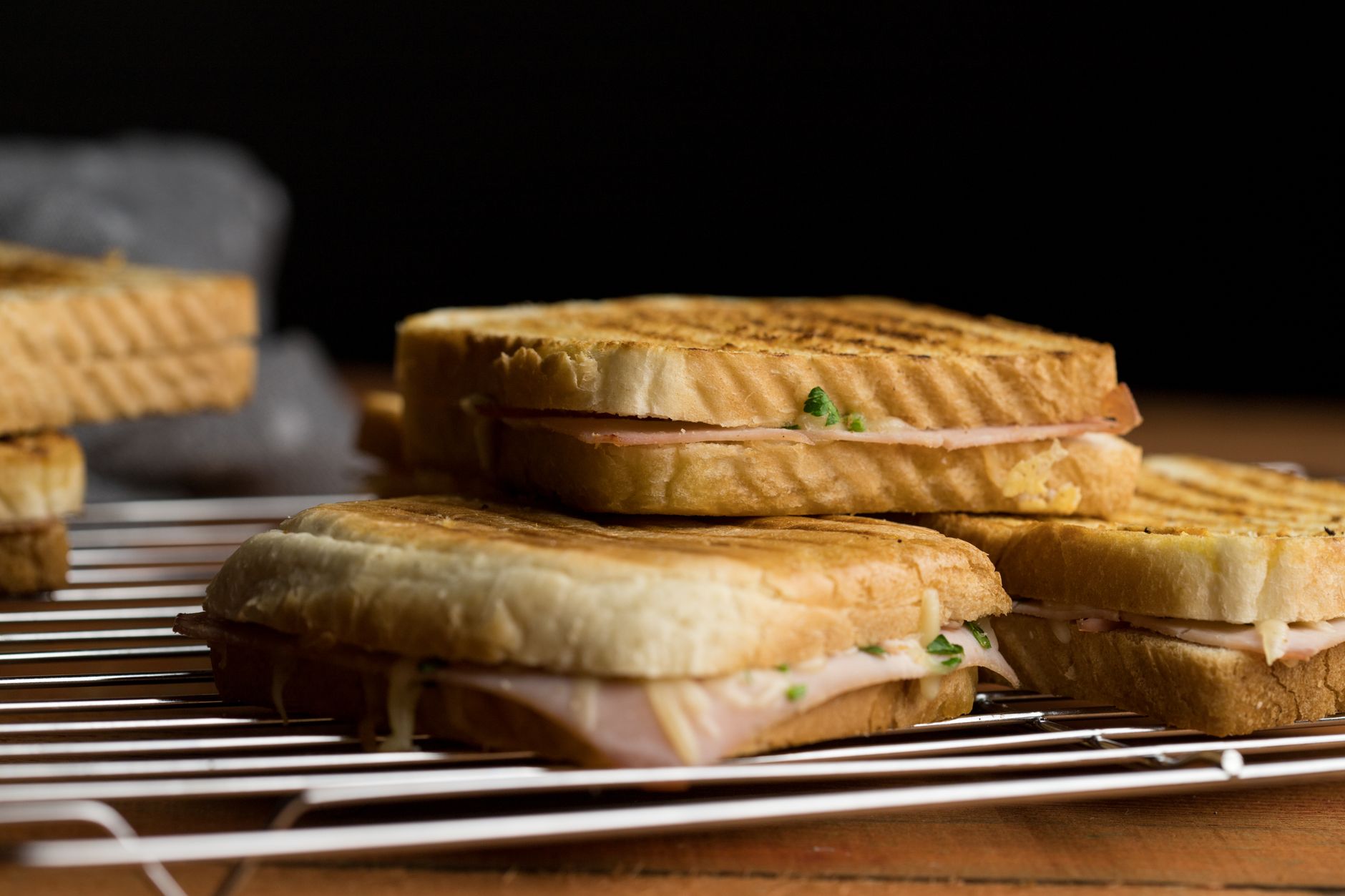 Freshly grilled sandwiches on a cooling rack, showcasing toasted bread and filling for quick breakfast