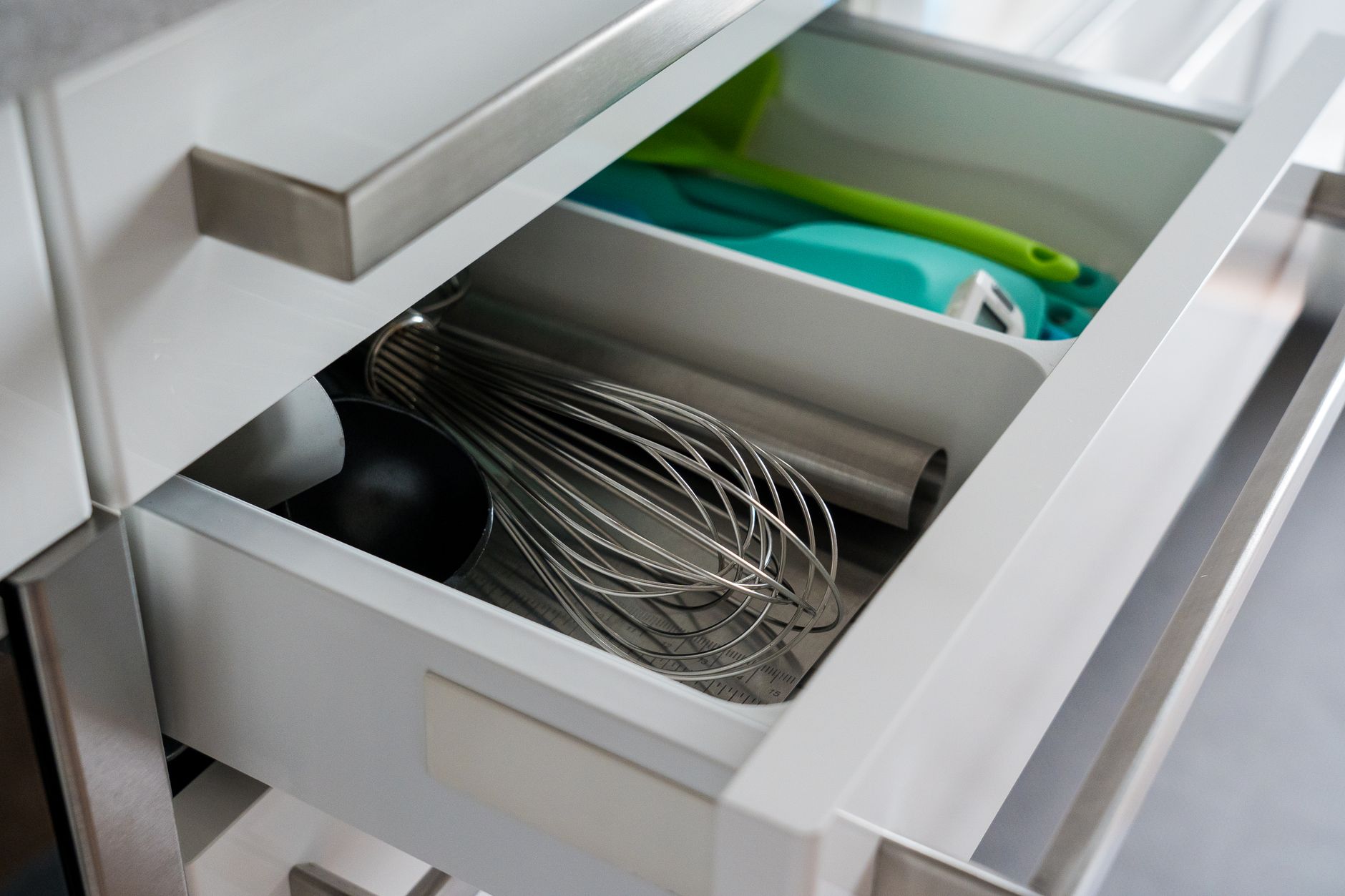 Kitchen drawer organizer with whisk and cooking utensils neatly arranged