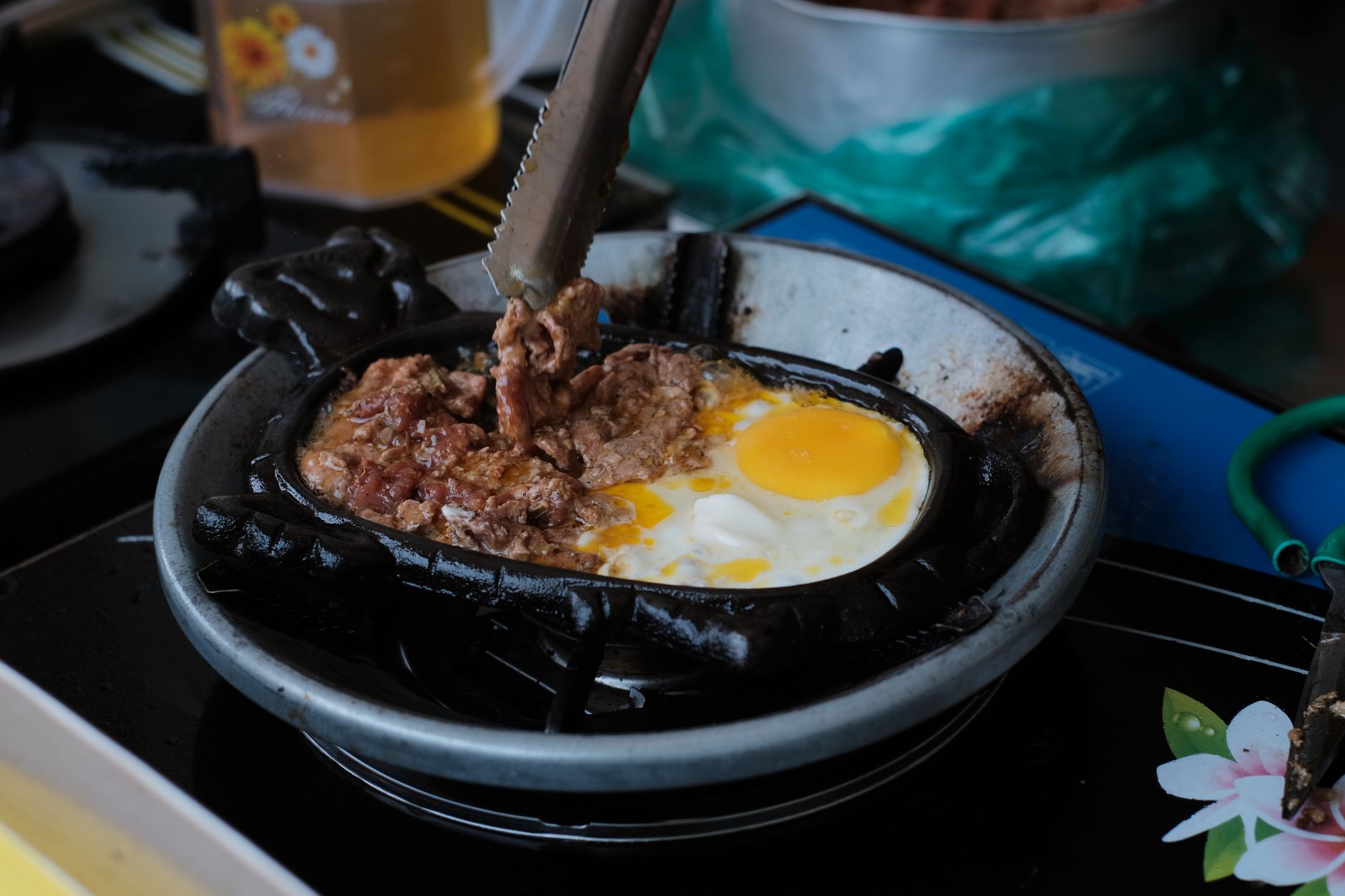 Close up of food cooking in iron pan on stove - cast iron cookware India