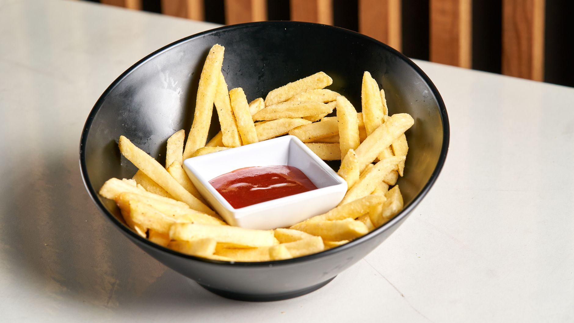 Crispy French fries with ketchup in a bowl — easily made at home in minutes using a budget air fryer