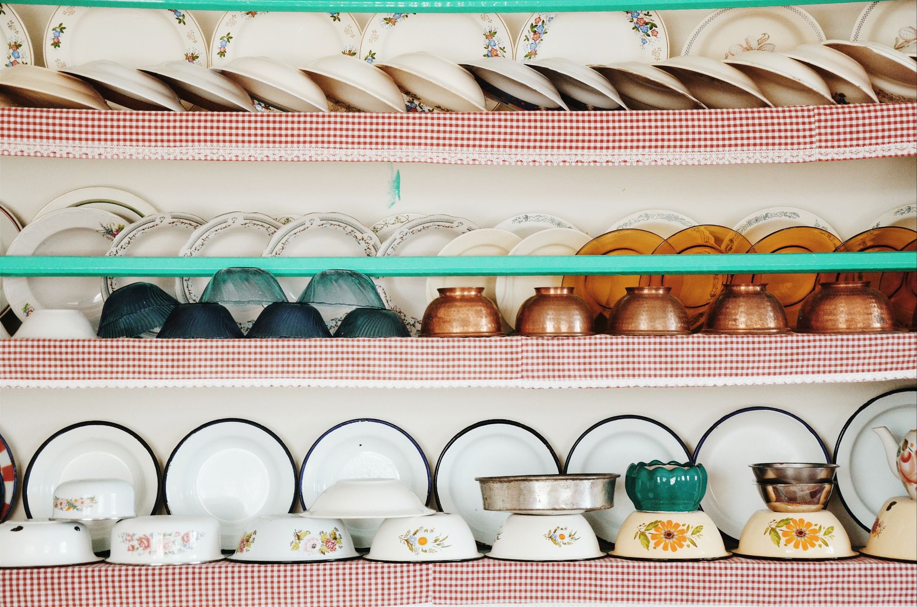 Organised kitchen shelves with metal and ceramic containers for pantry storage