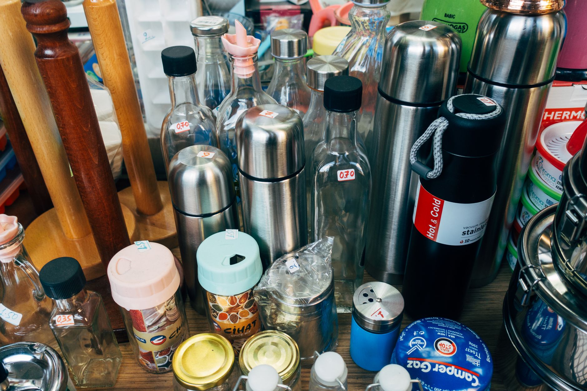 A variety of kitchen containers including stainless steel jars and thermos flasks
