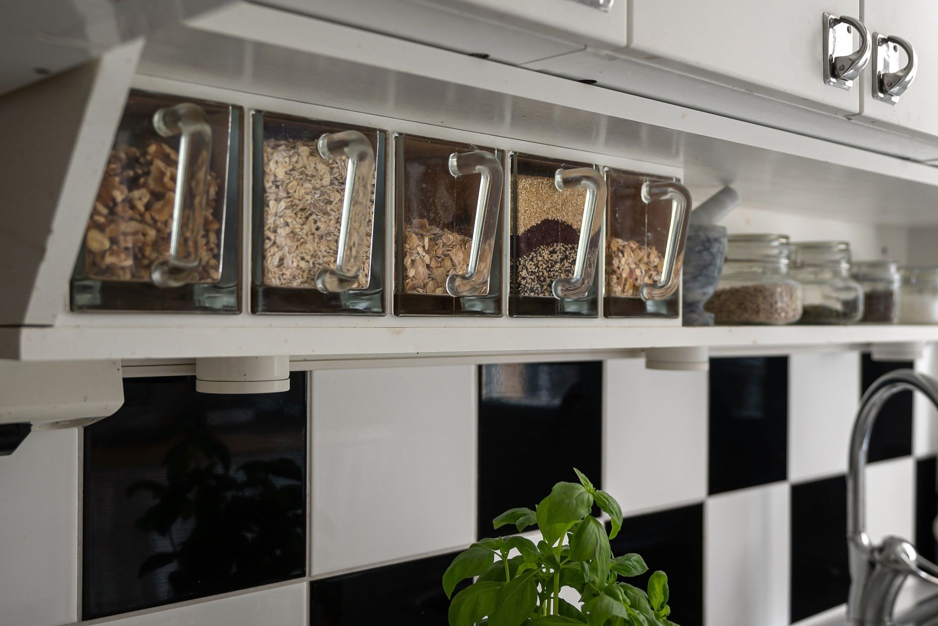Glass containers with dry food storage on kitchen shelf — vacuum sealer bags offer an airtight alternative for pantry items