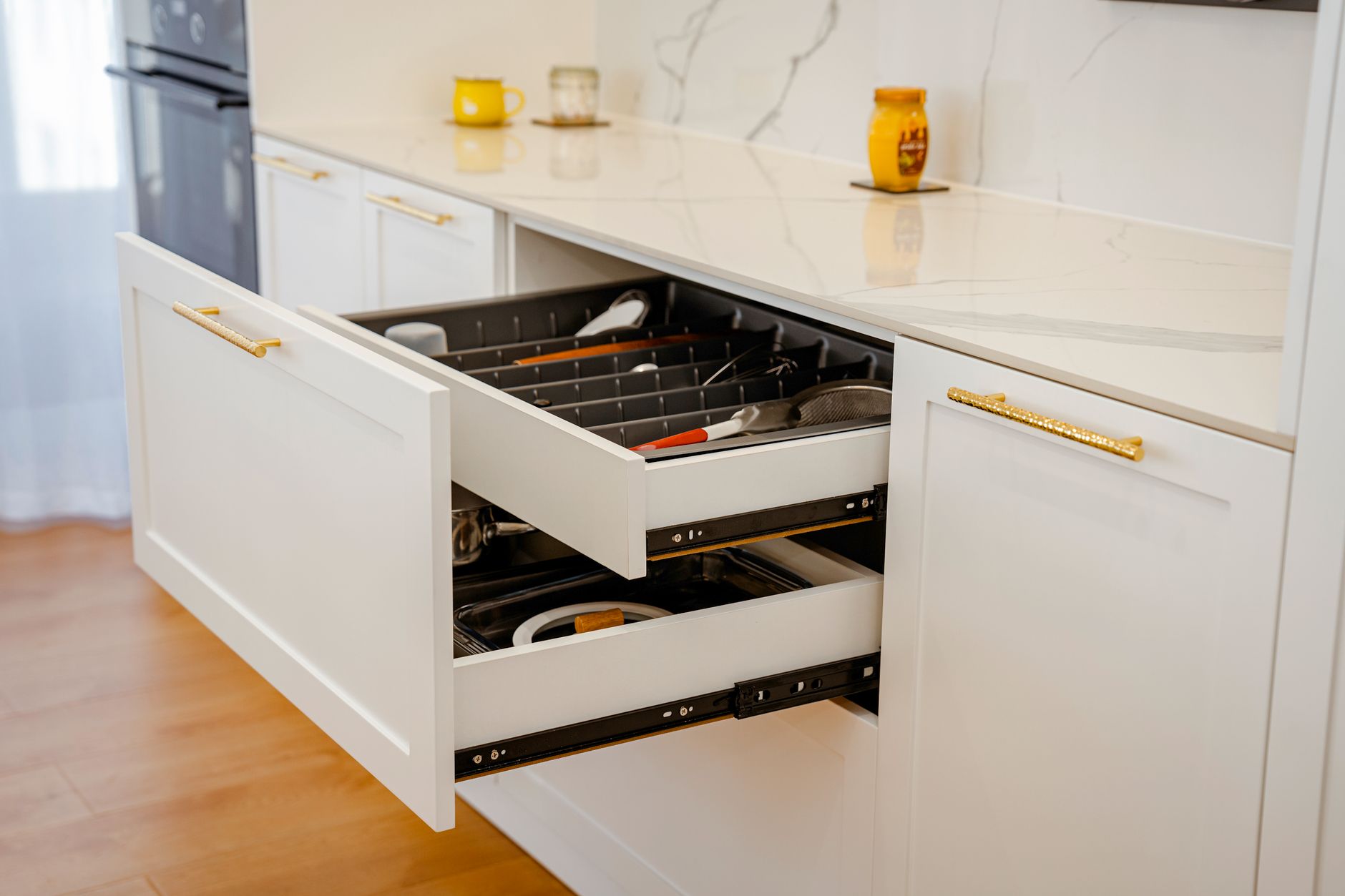 Kitchen drawer organiser with utensils neatly arranged on marble countertop in a modern Indian home