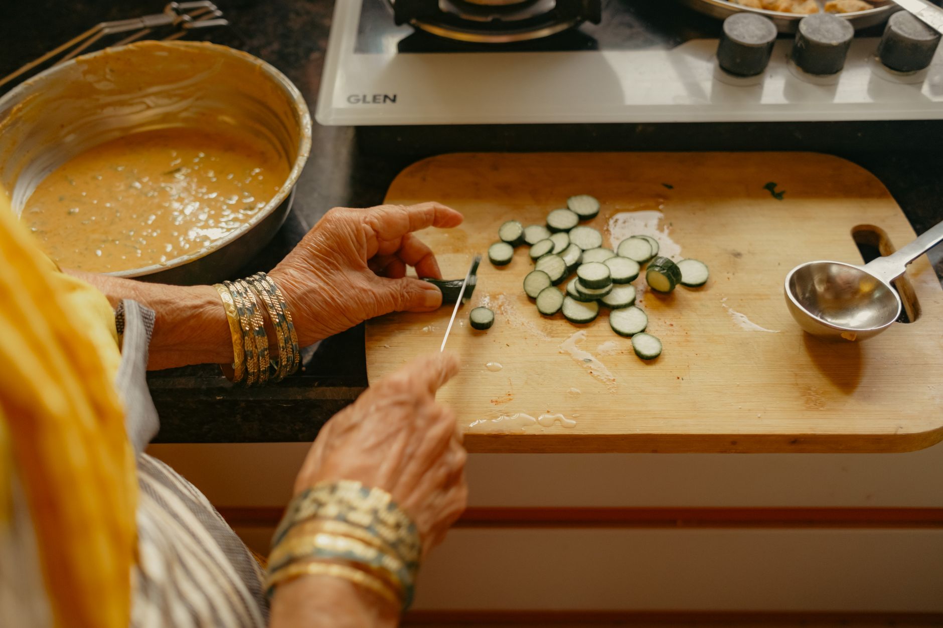Indian woman preparing food in traditional home kitchen — wet grinder is an essential appliance for South Indian cooking