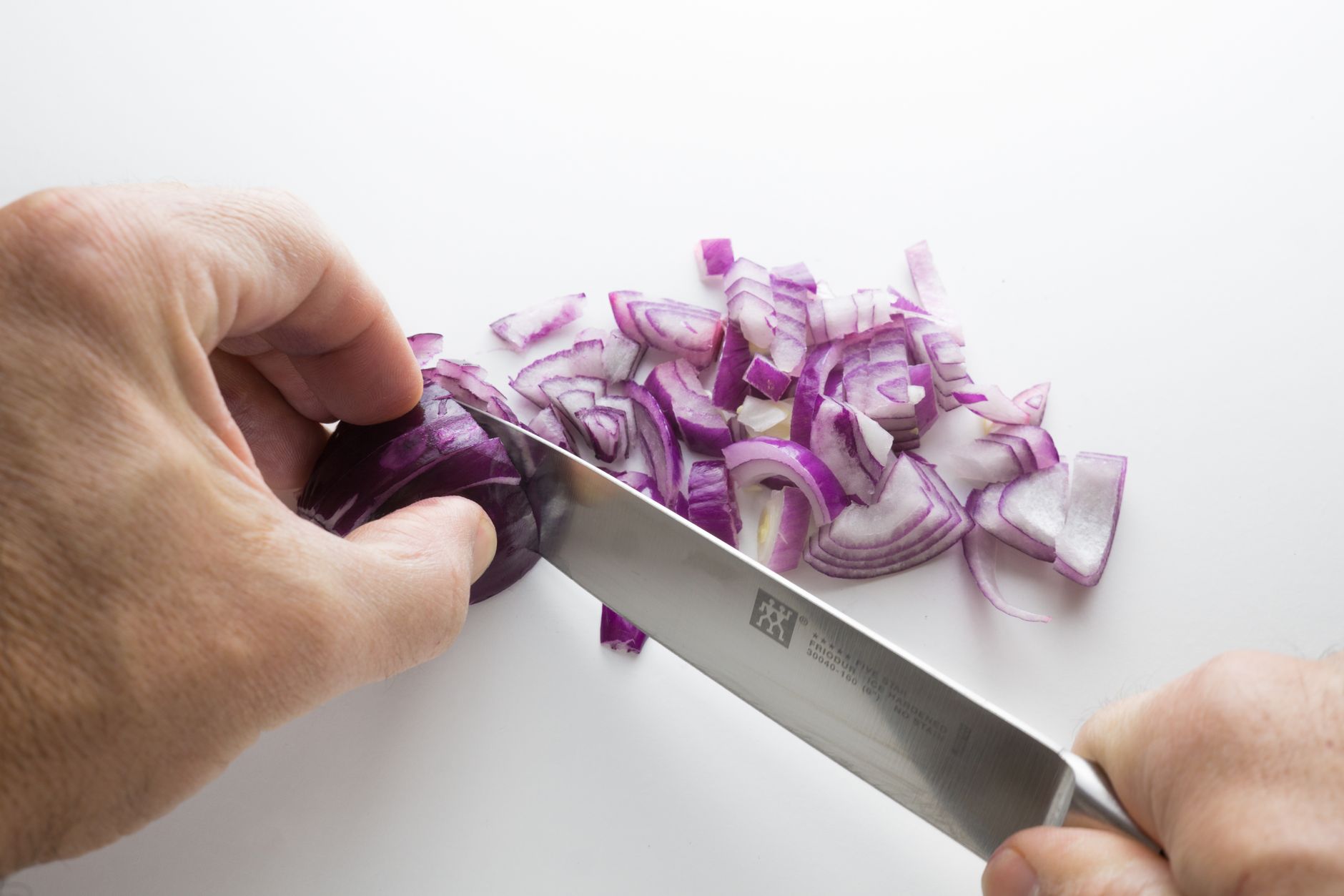 Manual hand chopper quickly dicing onions on a cutting board